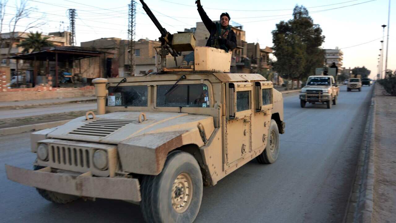 Fighters of Syria Democratic Forces (SDF) pose atop vehicles as a convoy drives towards Ghwayran prison in Hassakeh, northeastern Syria.