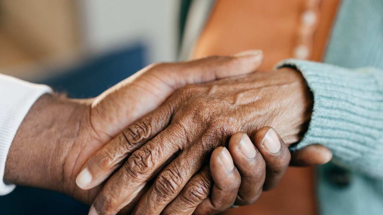Young woman holding elderly hands