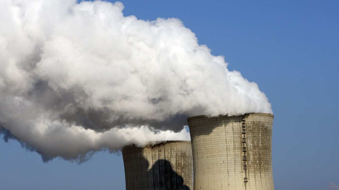 Steam pouring from two large concrete towers