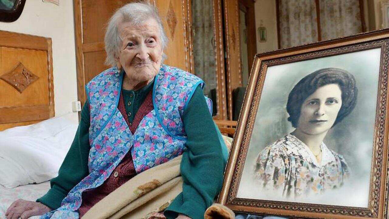 Emma Morano poses next to a picture depicting her when she was young, in Verbania, Italy, Friday, May 13, 2016