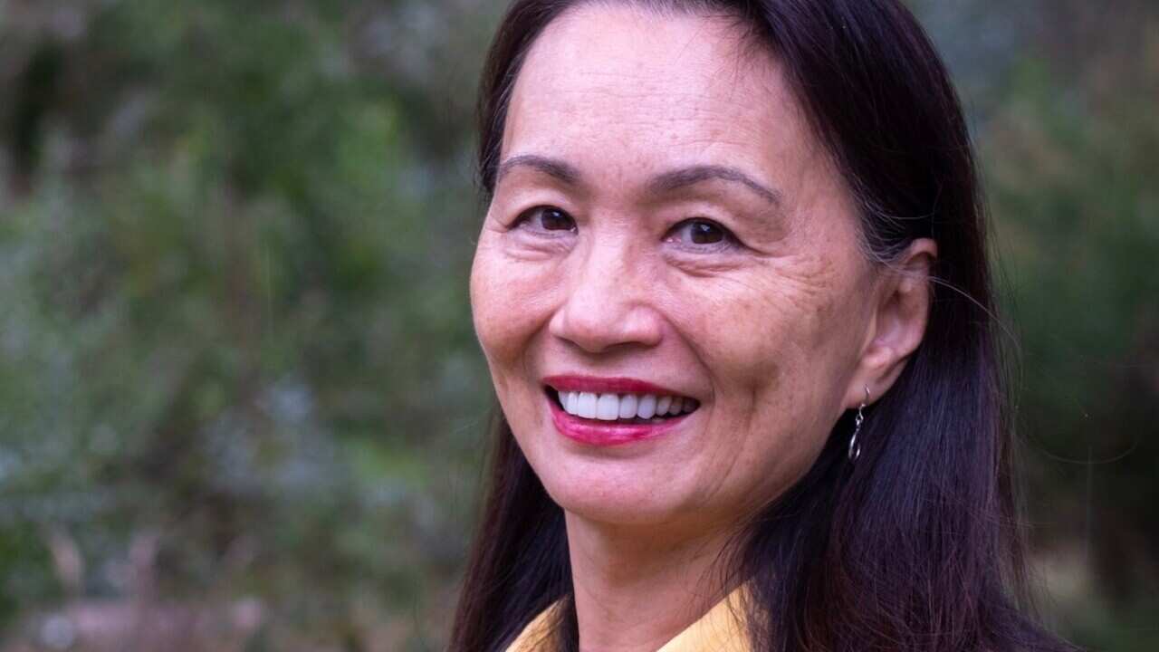 Photo of Asian woman in her 60s in yellow shirt