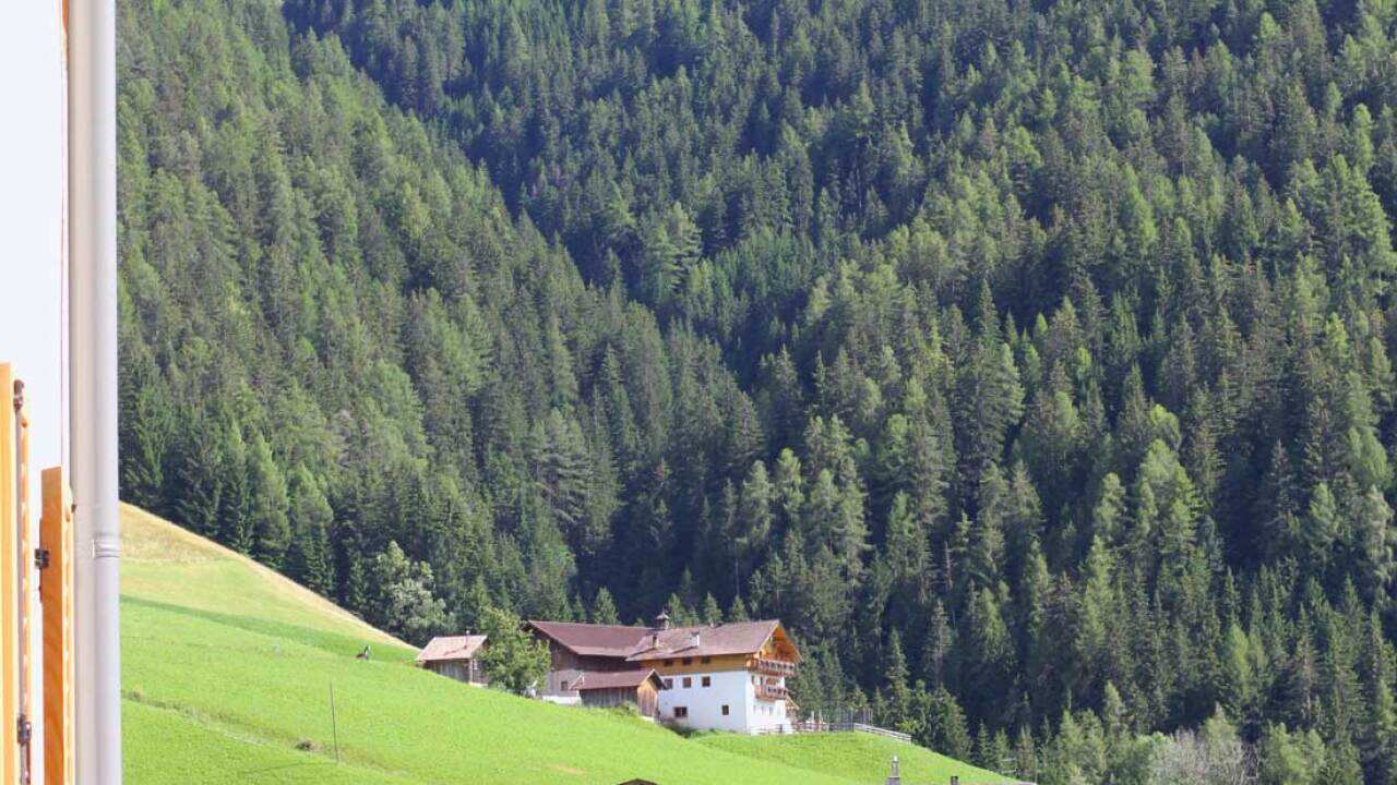 A shepherd hangs his clothes out to dry, overlooking his mountainside property in the Villnöss Valley