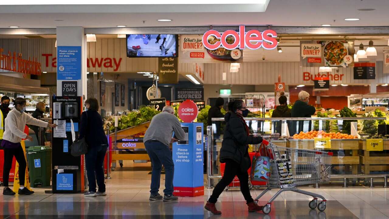 A person pushes a trolley in front of a supermarket.