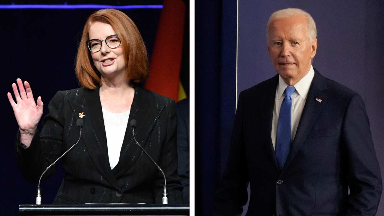 A composite image of a woman in a black suit speaking at a lectern (Julia Gillard) and a man in a navy suit white shirt and blue tie (Joe Biden).