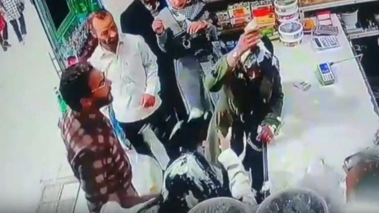 CCTV footage showing people in a shop. Two woman have had yoghurt thrown at them