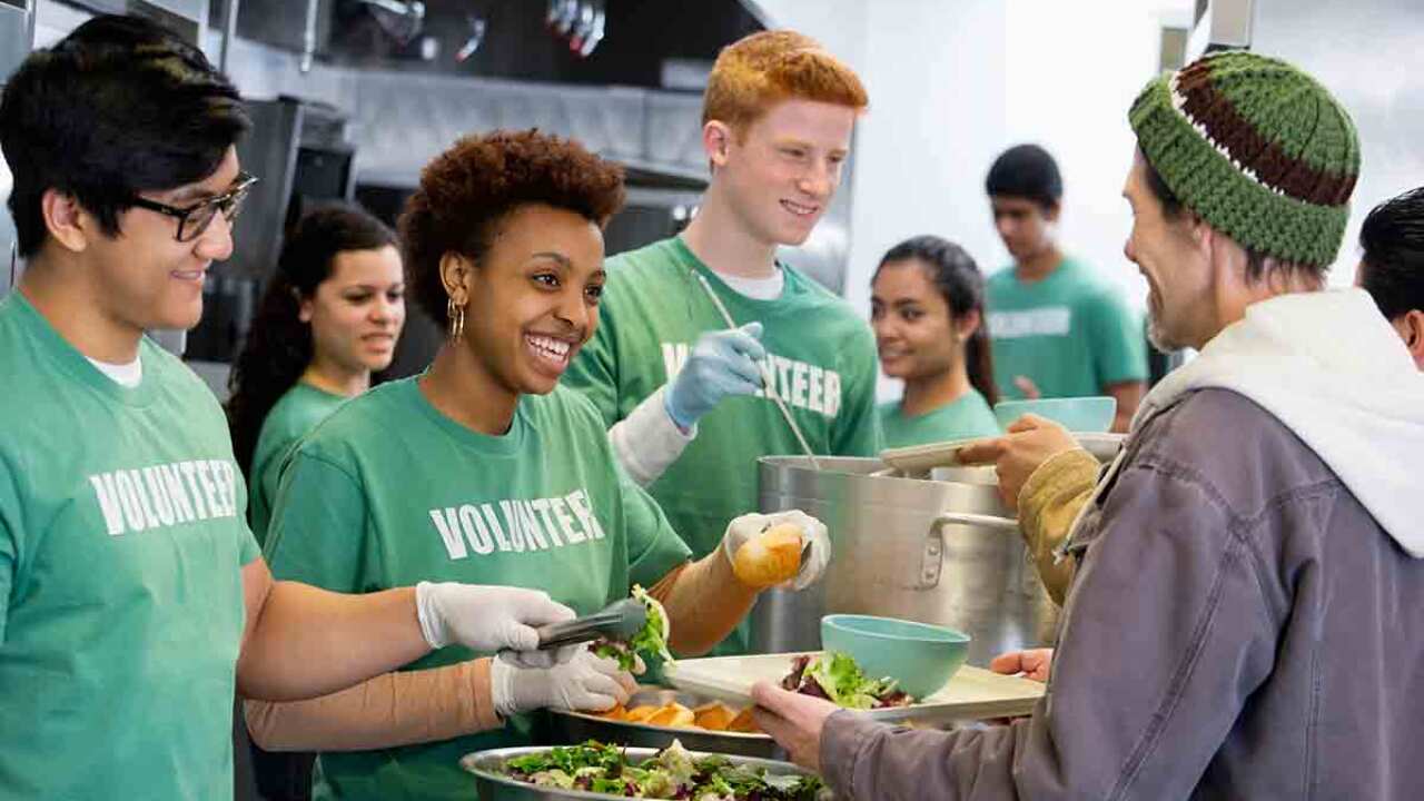 Volunteers serving food for homeless people