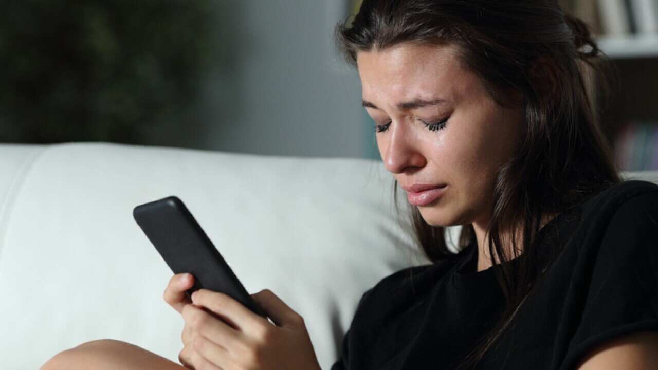 Sad teen crying for help on the phone.
