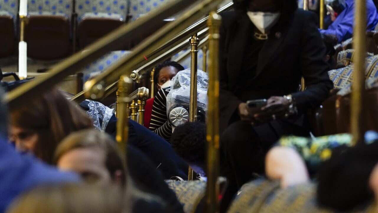 Politicians shelter as protesters try to break into the House Chamber at the Capitol on 6 January, 2021. 