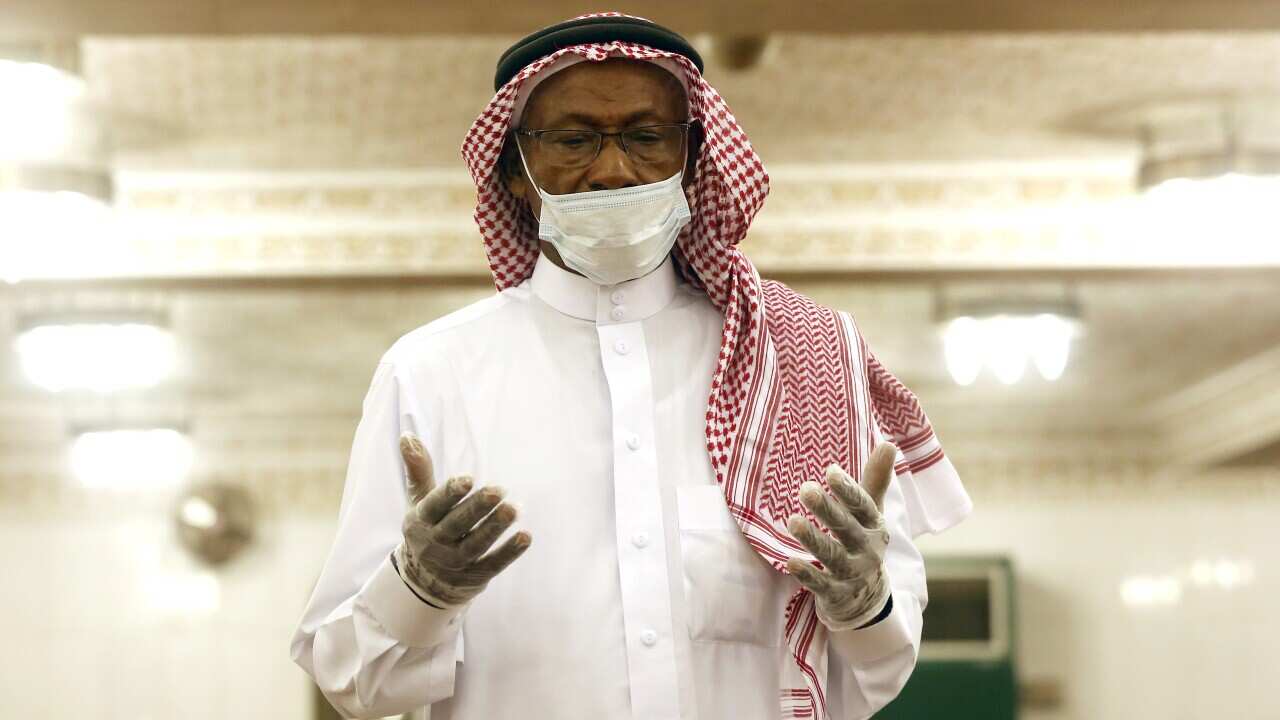 A Saudi worshipper wearing a face mask and gloves as he prays the dawn prayers at al-Mirabi Mosque in Jiddah, Saudi Arabia, Sunday, 31 May, 2020. 