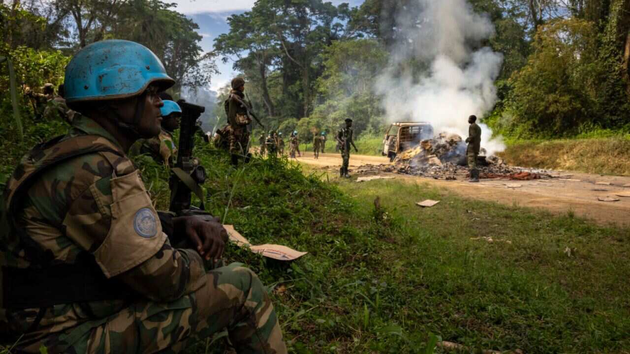 Congolese Army soldiers and UN forces inspect an ambush site where an hour previously ADF militia attacked two vehicles on the road near Beni on 9 April.