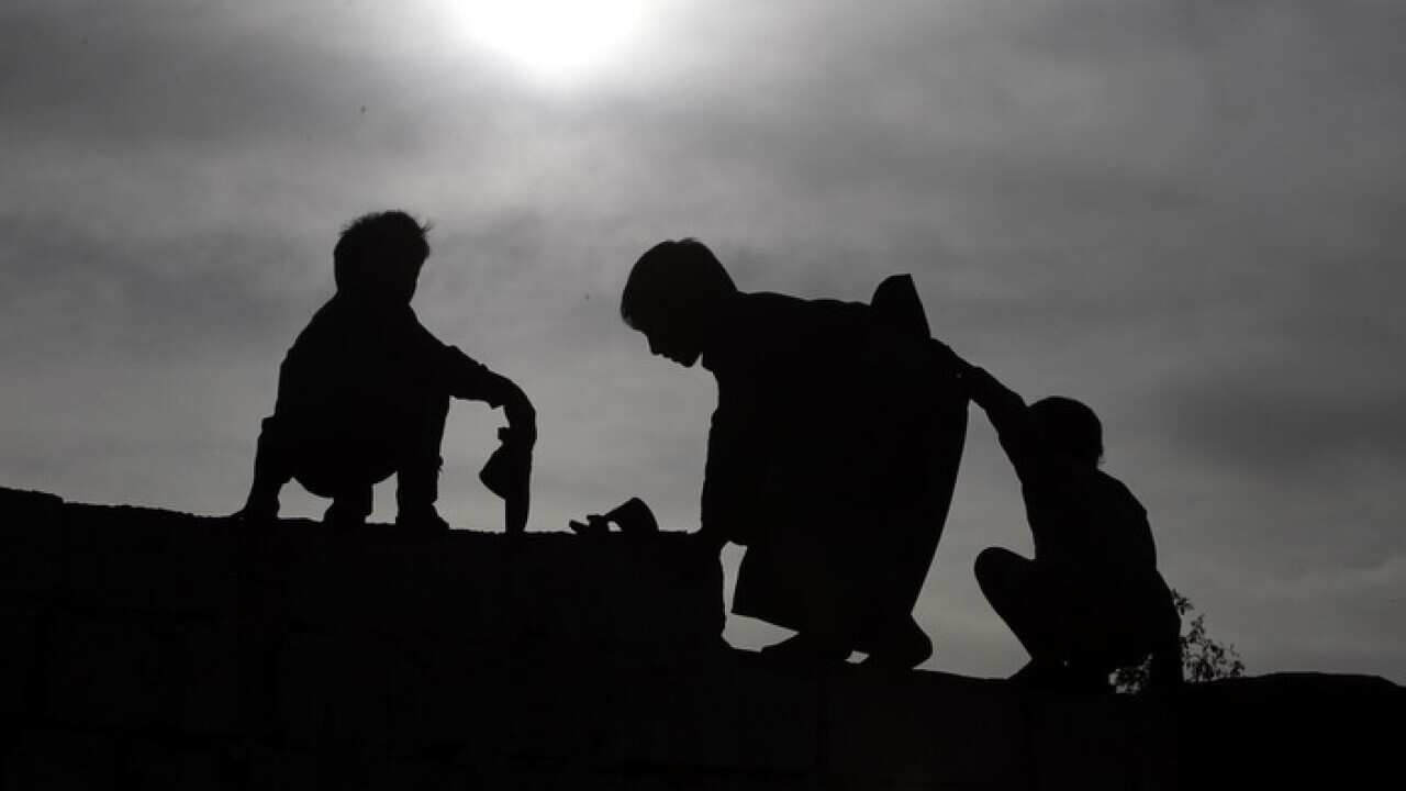Yemeni children walk on top of a wall in the eastern outskirts of Sanaa, Yemen