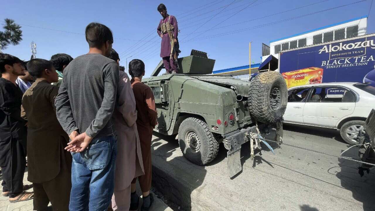 A member of the Afghan security force stands on a Humvee tank in Kabul, Afghanistan on 15 August 2021.