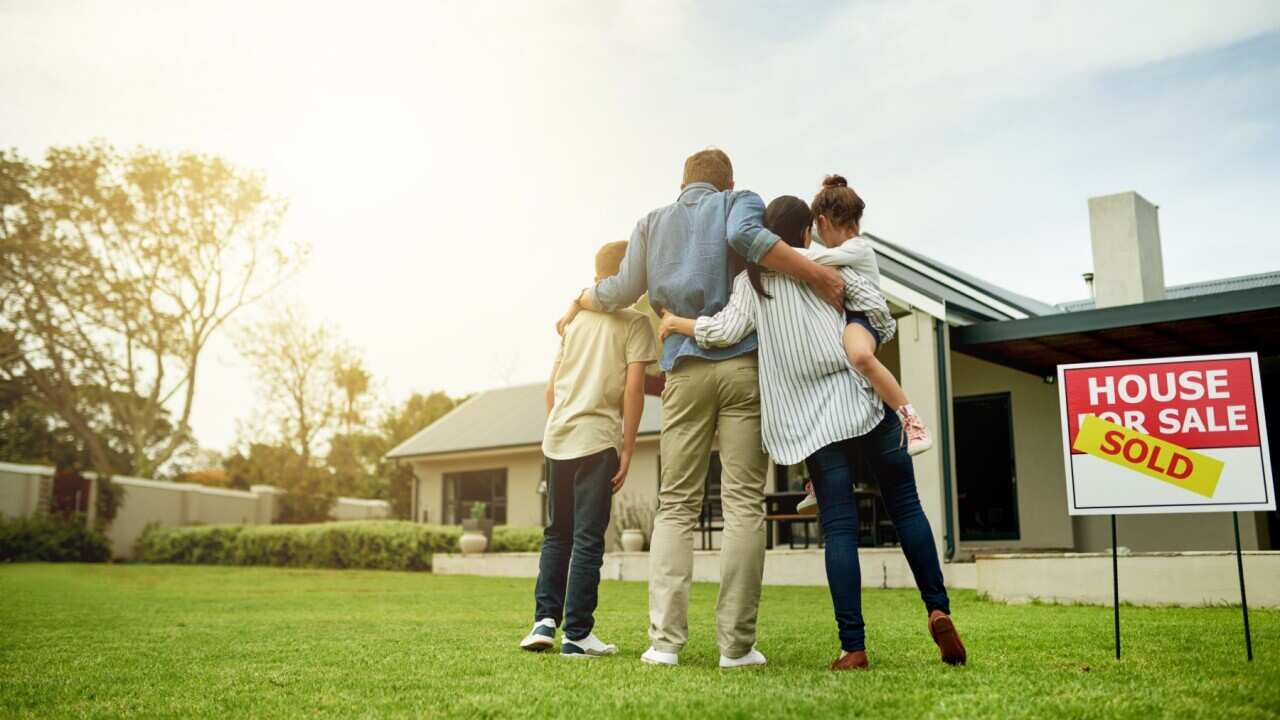 A family outside thier newly bought home