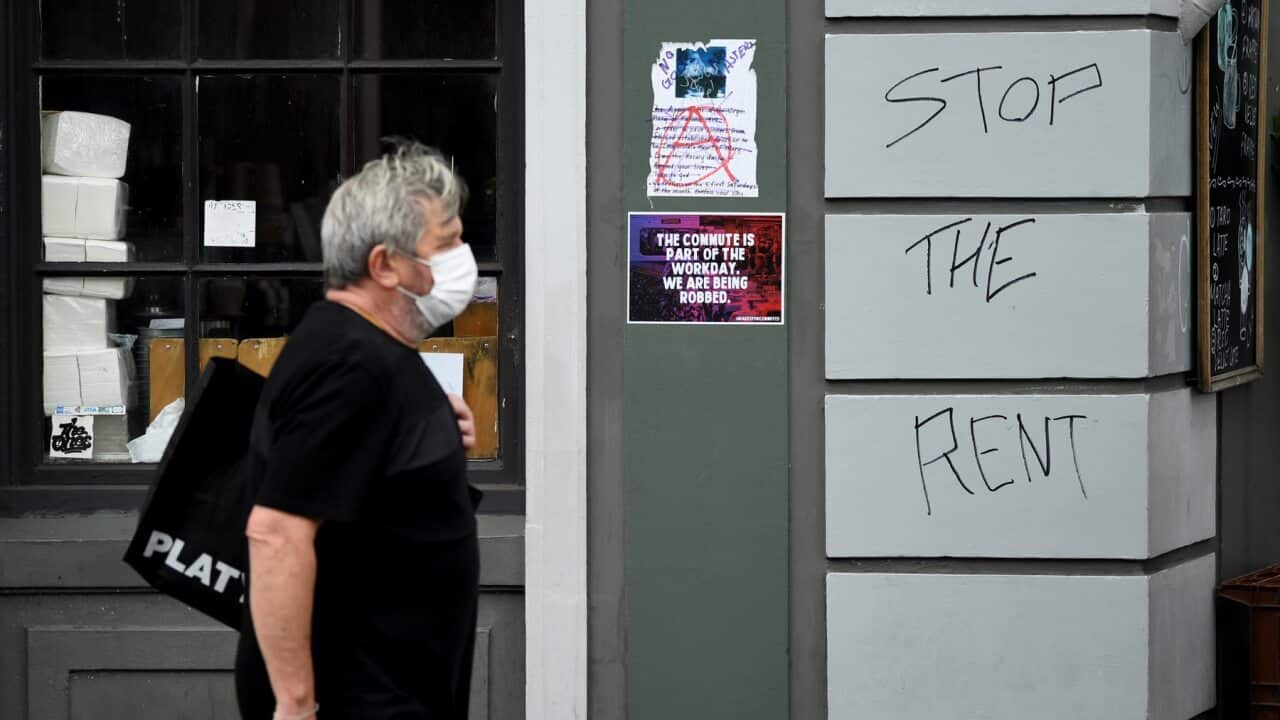 Man walks past shop with Stop the Rent plea (AAP)