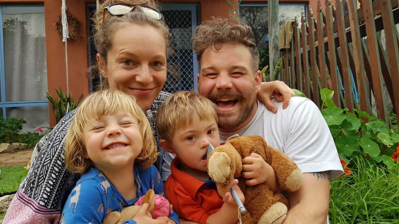 Parents with their two children smile into the camera