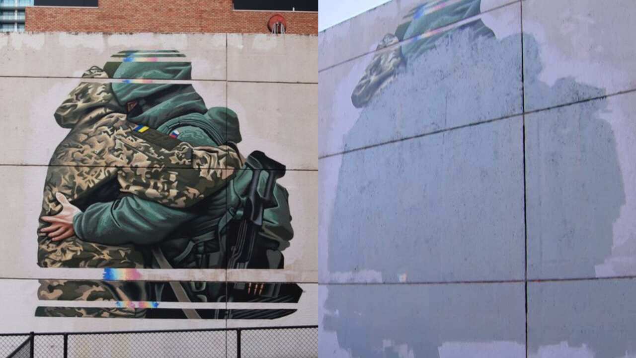 Left side of image shows a mural of Russian and Ukrainian soldier hugging. Right side shows a blank wall.