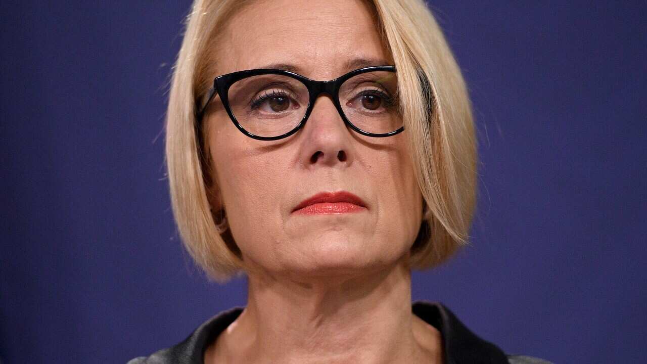 A woman listens during a press conference.