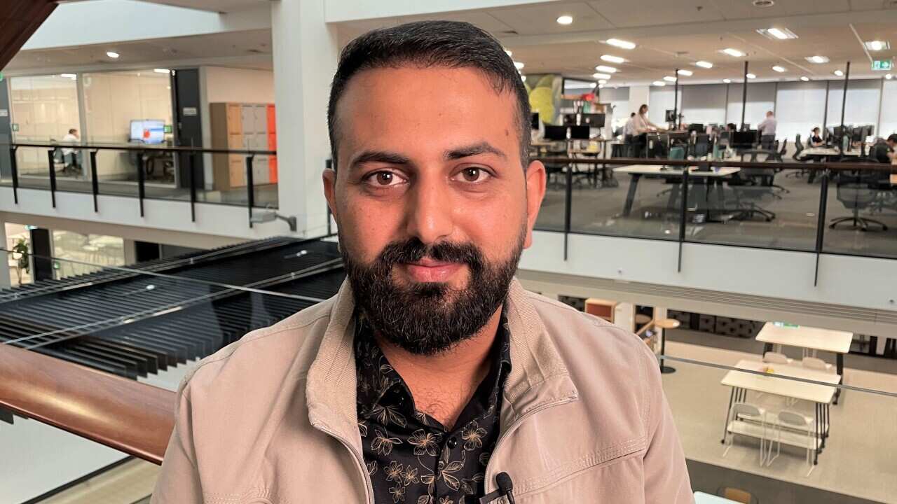 Jahidullah Tokhi sitting at his workplace in Sydney.