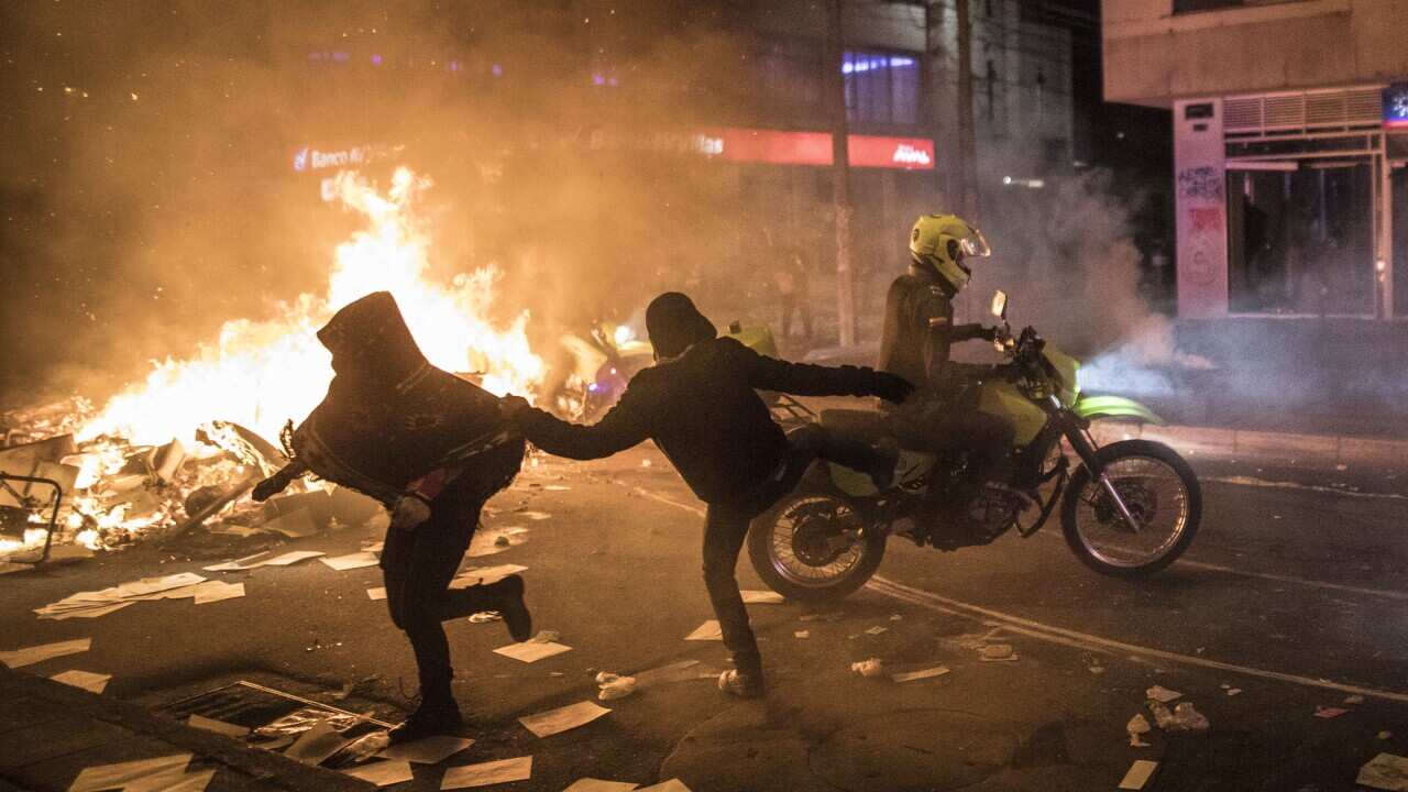 A demonstrator kicks a police officer on a motorcycle during protests in Bogota, on 9 September.