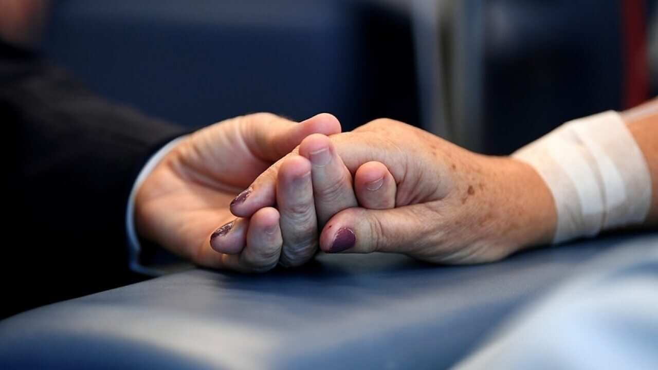 Image of an elderly person's hand being held