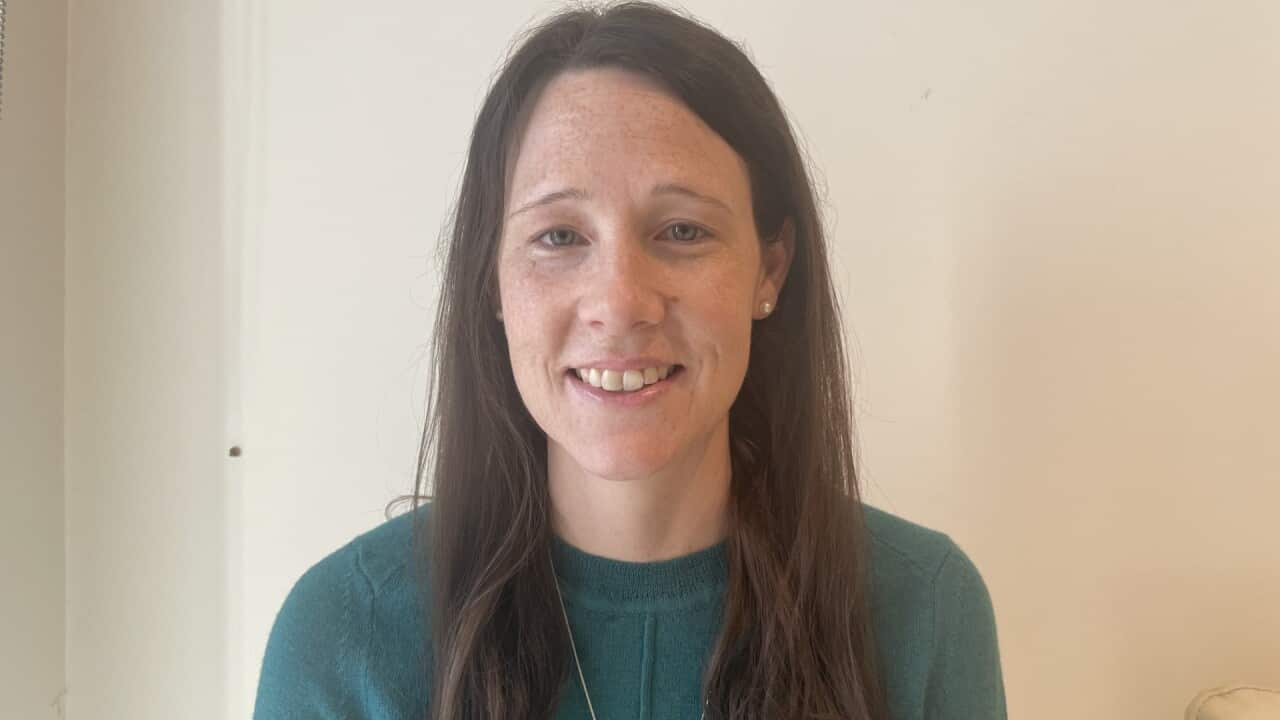 Stephanie Webster wears a green long sleever top and silver necklace while she smiles at the camera.