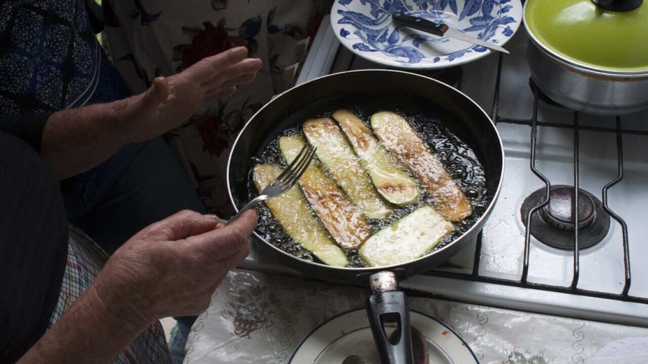 Zucchinis being fried by Tsintziras' mother for the dish, soufiko.