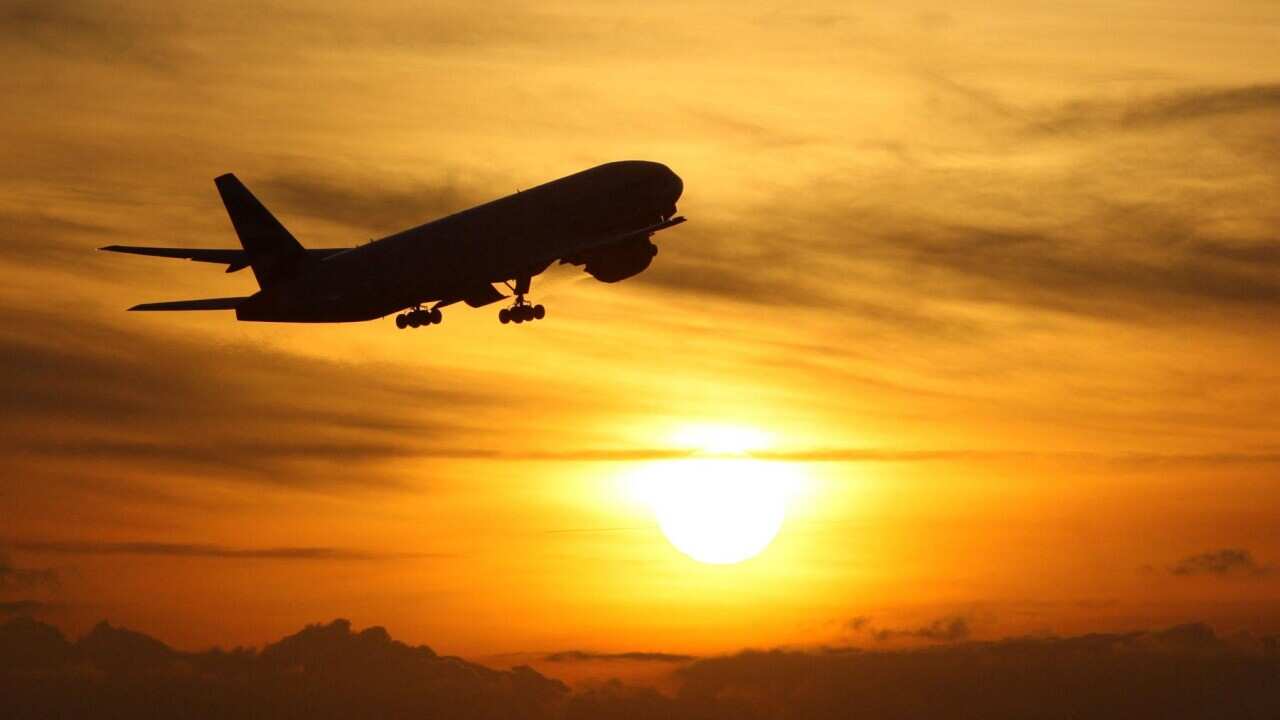 A plane takes off at sunset