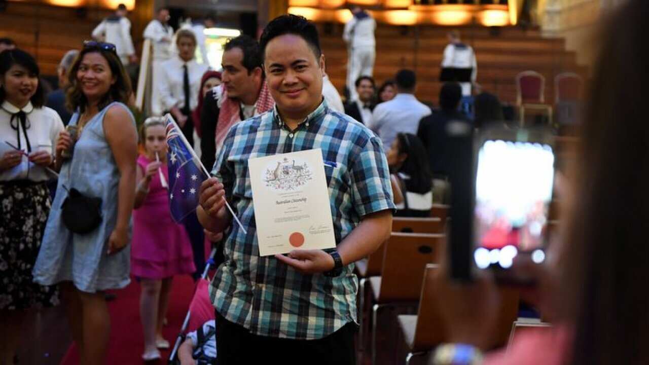 An Australian citizenship recipient poses for a photo after  a citizenship ceremony on Australia Day in Brisbane.