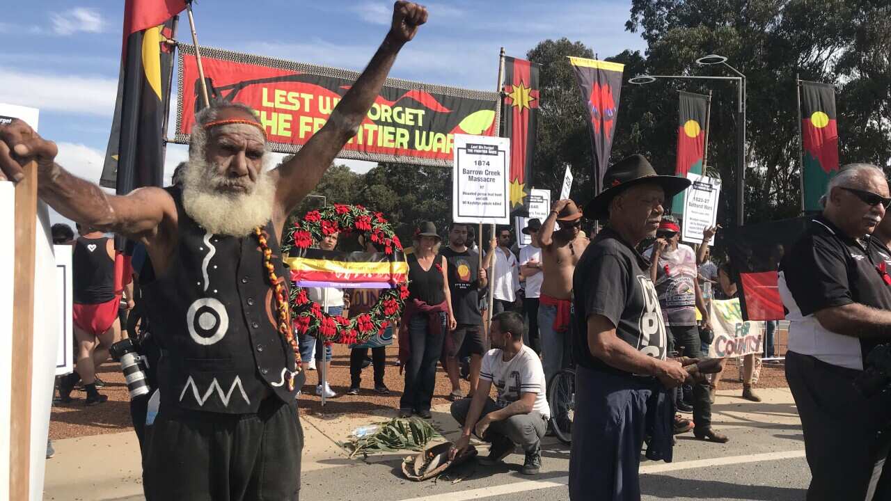 Man with his fist raised in front of the protest