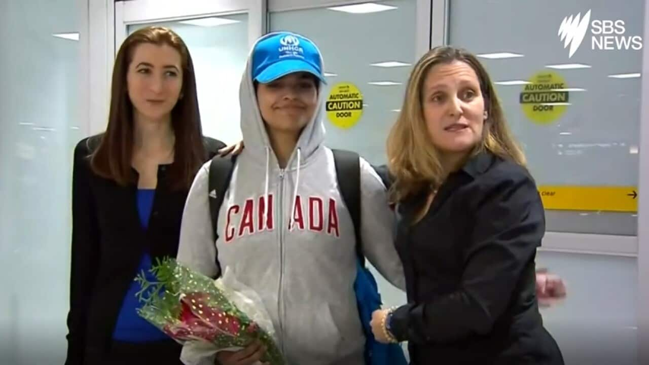 Image of Ms Qunun smiling broadly as she exited an arrival door wearing a Canada hoodie.