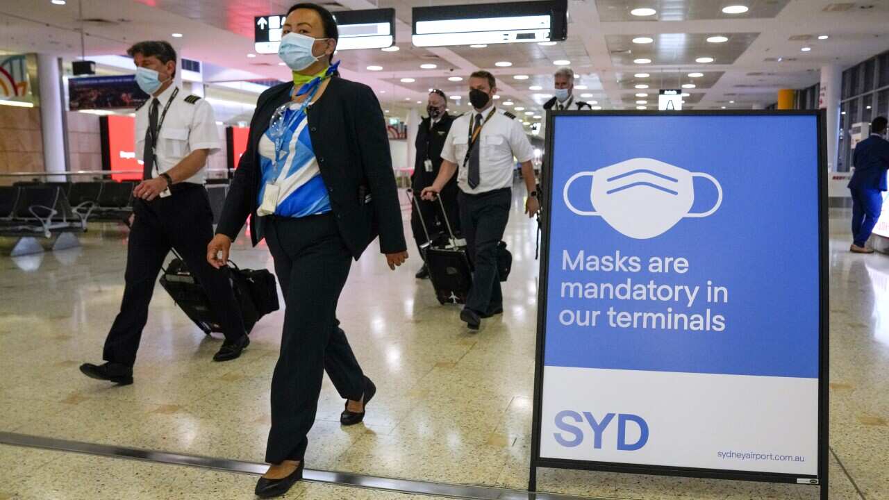 A flight crew walk through the terminal at Sydney Airport on 29 November, 2021.