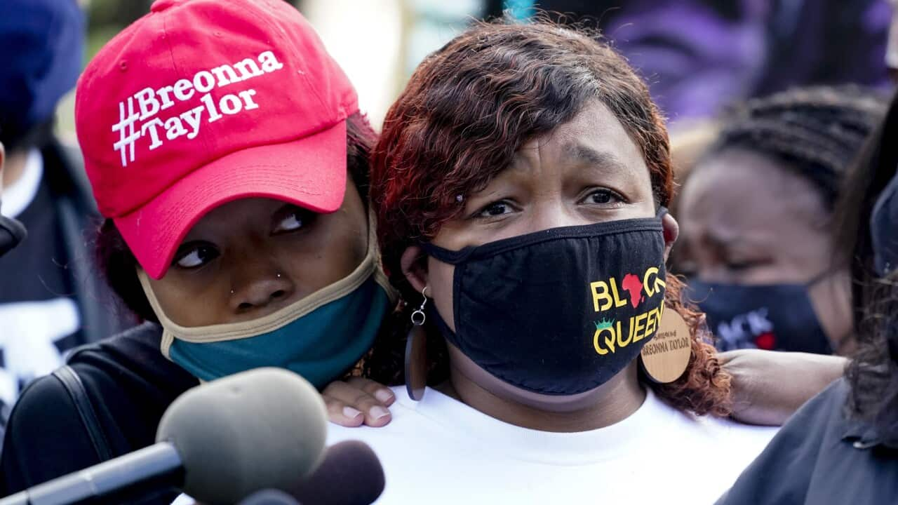 Breonna Taylor's mother Tamika Palmer, right, listens to a news conference on 25 September.