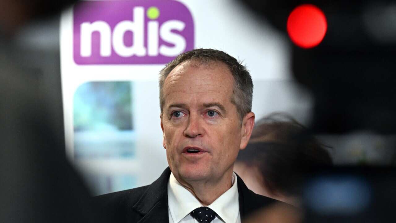 Bill Shorten speaking with NDIS logo in background