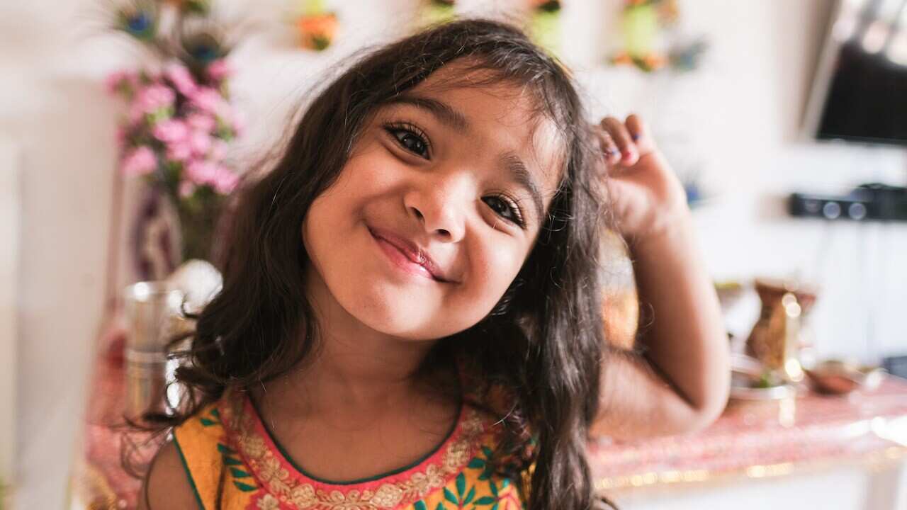 Cute indian girl with traditional dress celebrating religion hindu event at home - Focus on the nose