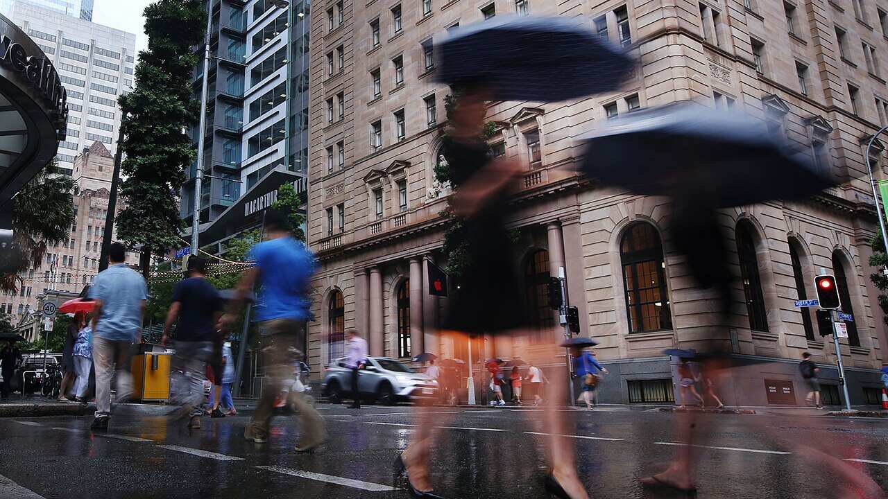 Pedestrians walk through the Brisbane CBD during rain, Brisbane, Monday, December 4, 2017. 