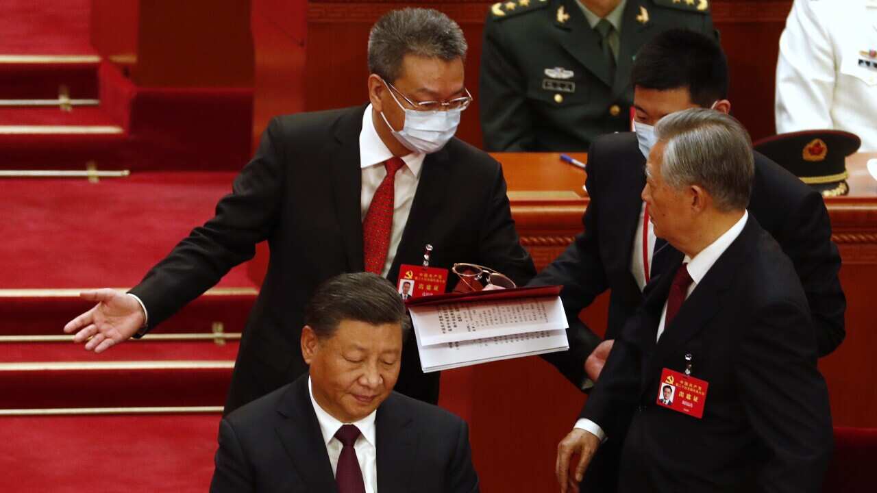 Former Chinese president Hu Jintao (right) is led out of the 20th National Congress of the Communist Party of China.