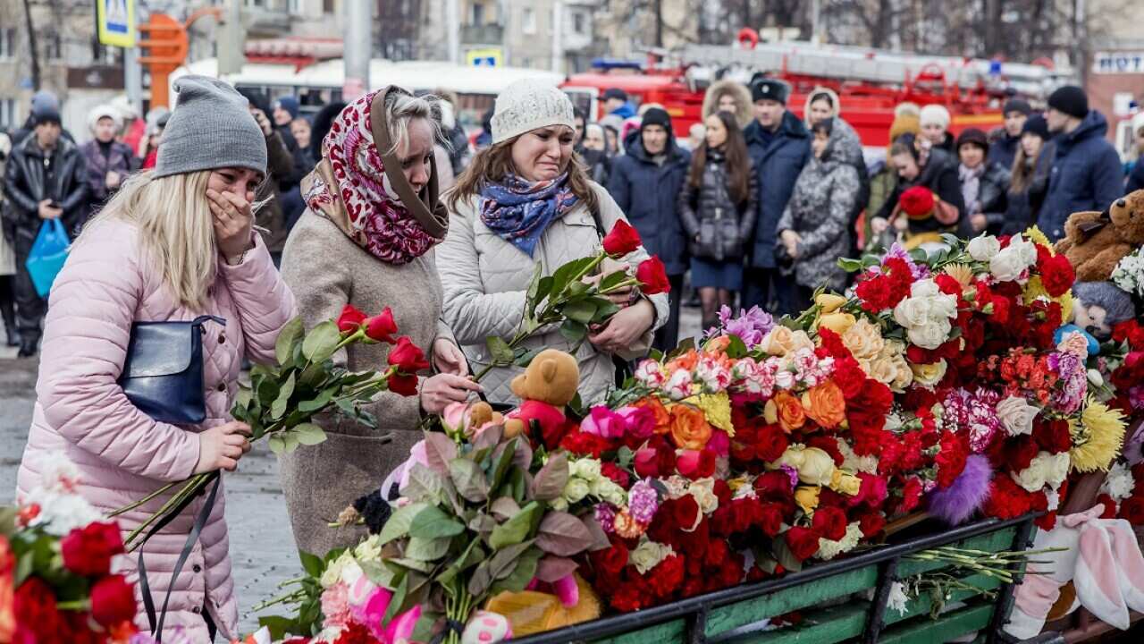 People lay flowers in memory of those that died in the fire.