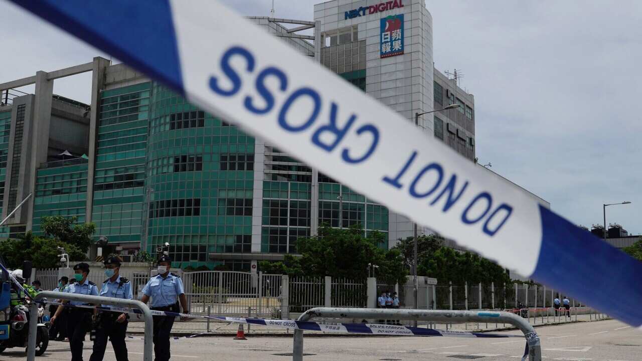 Police officers stand guard outside Apple Daily headquarters as Hong Kong media tycoon Jimmy Lai, who founded local newspaper Apple Daily, is arrested by police at his home in Hong Kong on Aug. 10, 2020. The Apple Daily editors and executives were detaine