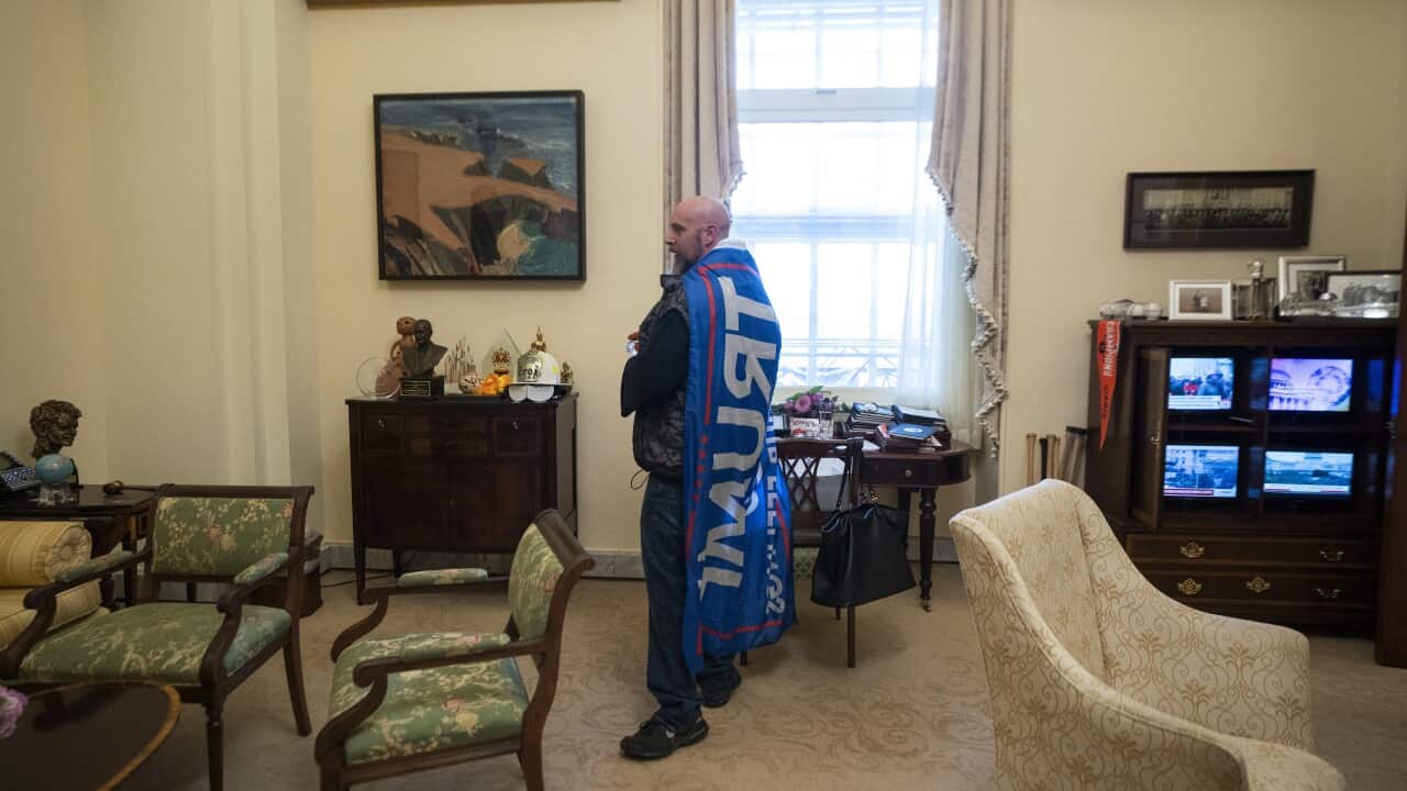 A supporter of US President Donald Trump stands inside the office of House Speaker Nancy Pelosi, after breaching the US Capitol security on 6 January.