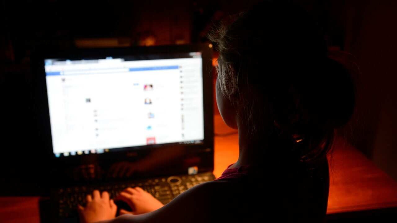 A young girl uses a personal computer in Brisbane, Wednesday, Oct. 16, 2013. (AAP Image/Dan Peled) NO ARCHIVING