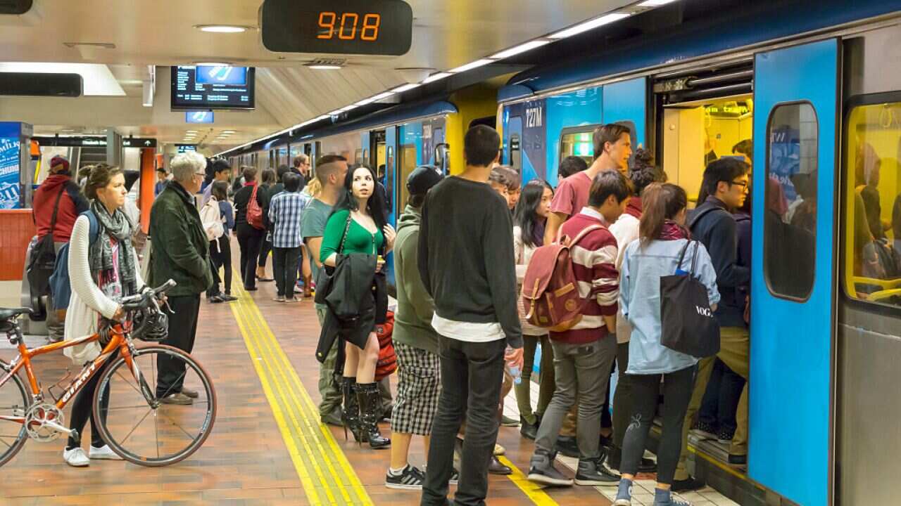 Australia, Victoria Melbourne Flagstaff Railway Station Metro platform passengers boarding woman bicycle