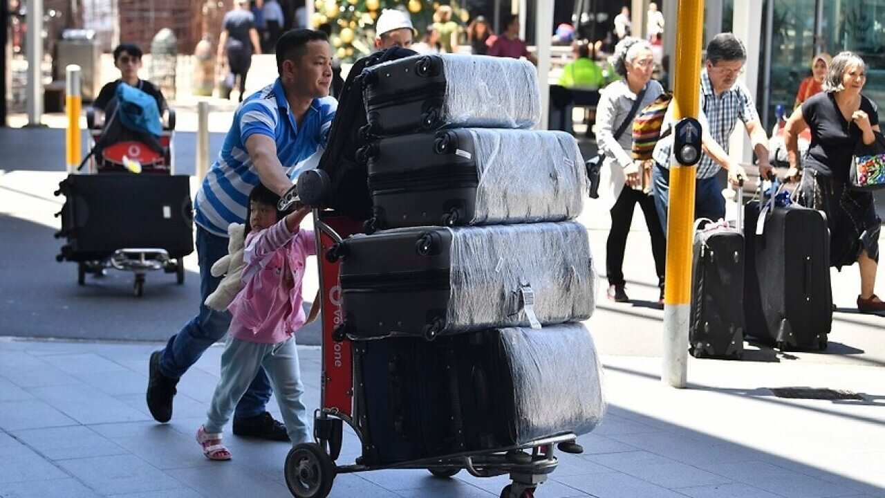 Image of an Asian family with luggage on an airport trolly