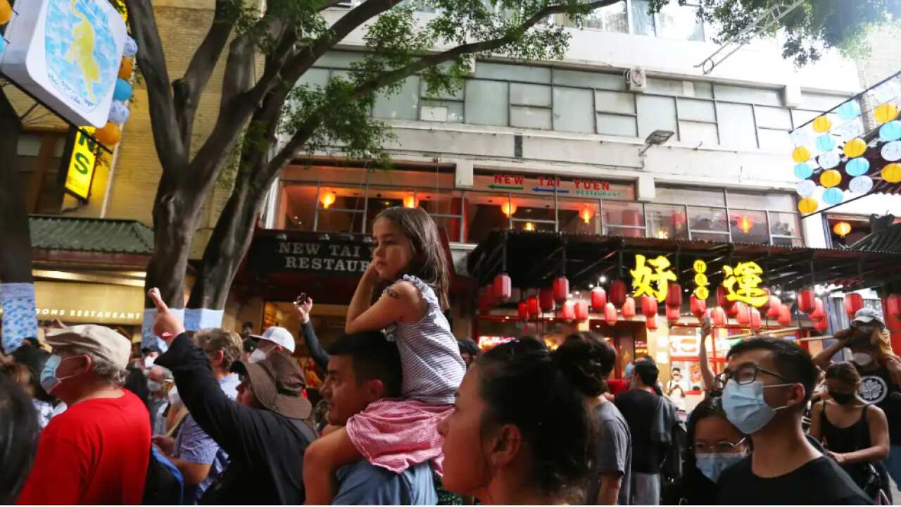 Crowds gather in the Chinatown district to watch street performers on 29 January 2022 in Sydney. Credit: Lisa Maree Williams/Getty Images