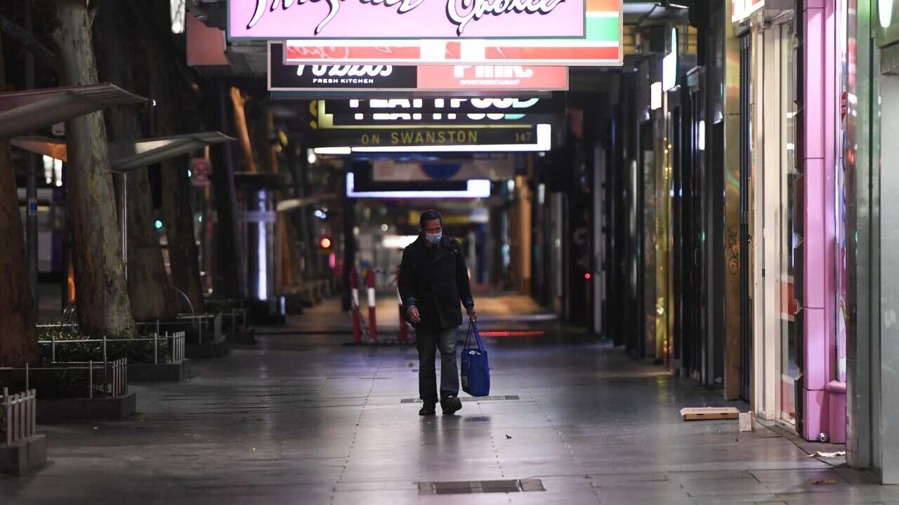 A man walks down Swanston Street after a citywide curfew is introduced in Melbourne.