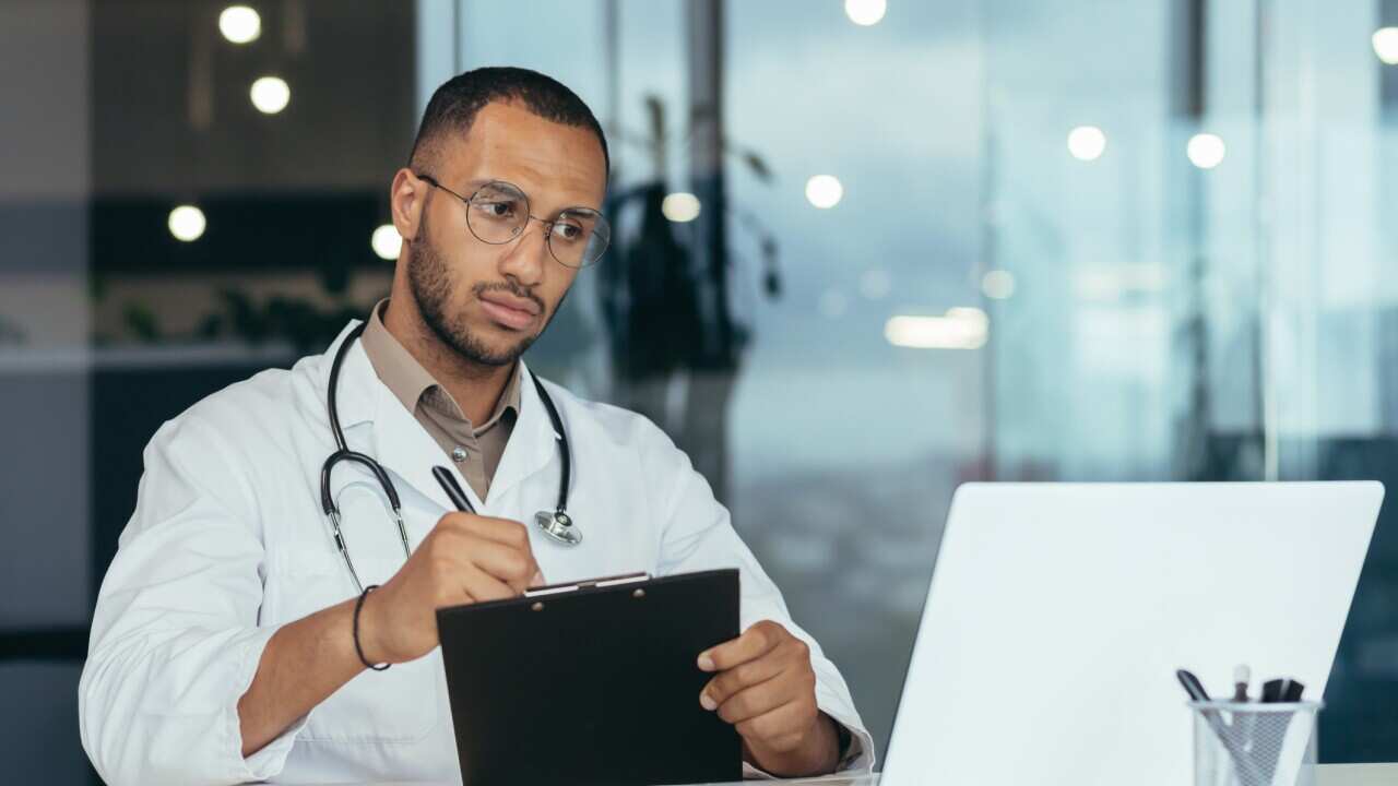 A man, a Latin American student, a trainee doctor, an intern studies via video link from a laptop