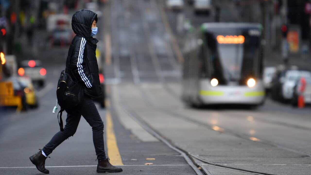 A person is seen wearing a face mask in Melbourne, Friday, June 4, 2021. Victoria has recorded four new locally acquired cases of coronavirus in the past 24 hours. (AAP Image/James Ross) NO ARCHIVING