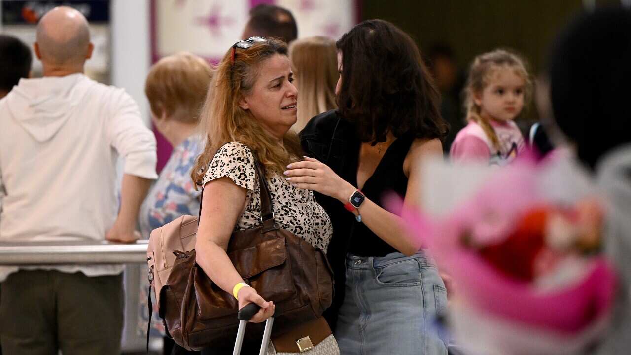 People embrace as Australian nationals arrival on a repatriation flight at Sydney International Airport in Sydney, Monday, October 7, 2024.