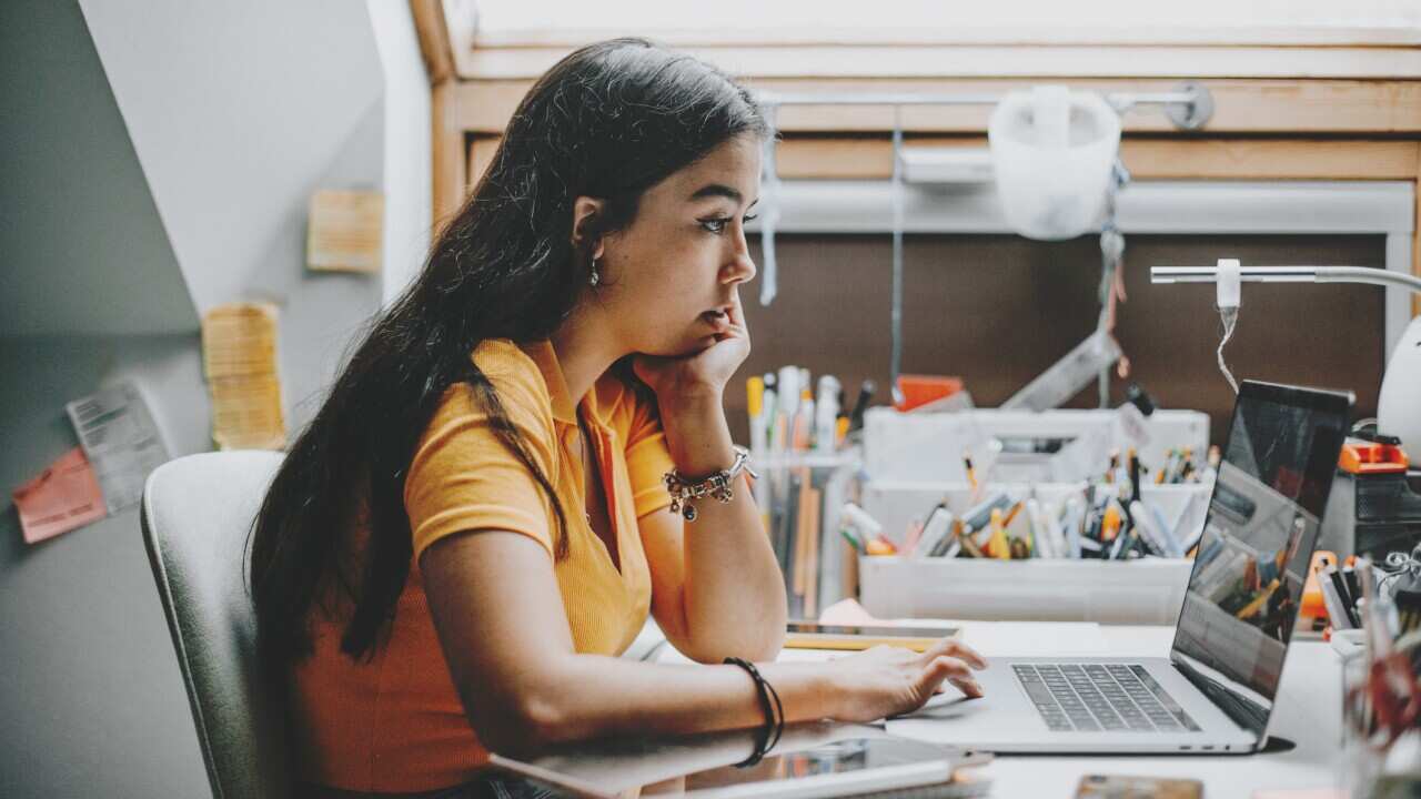 hispanic young woman working and studying from home using laptop