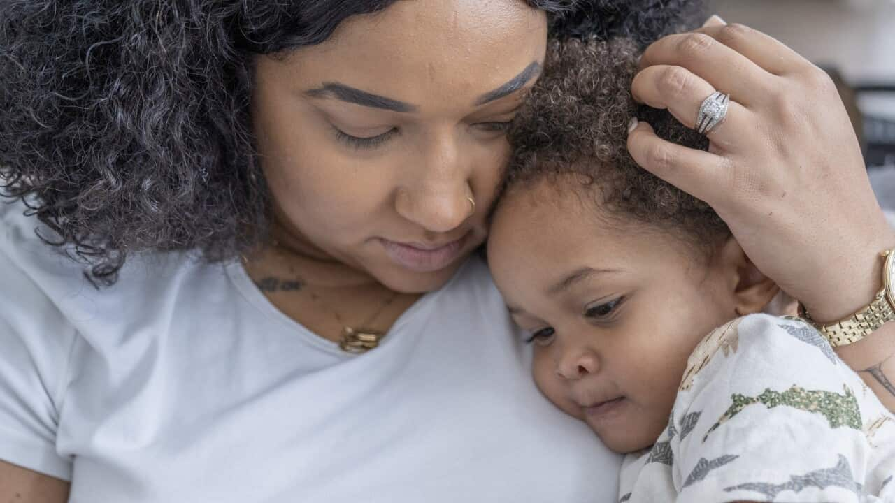 Mother snuggling sick child