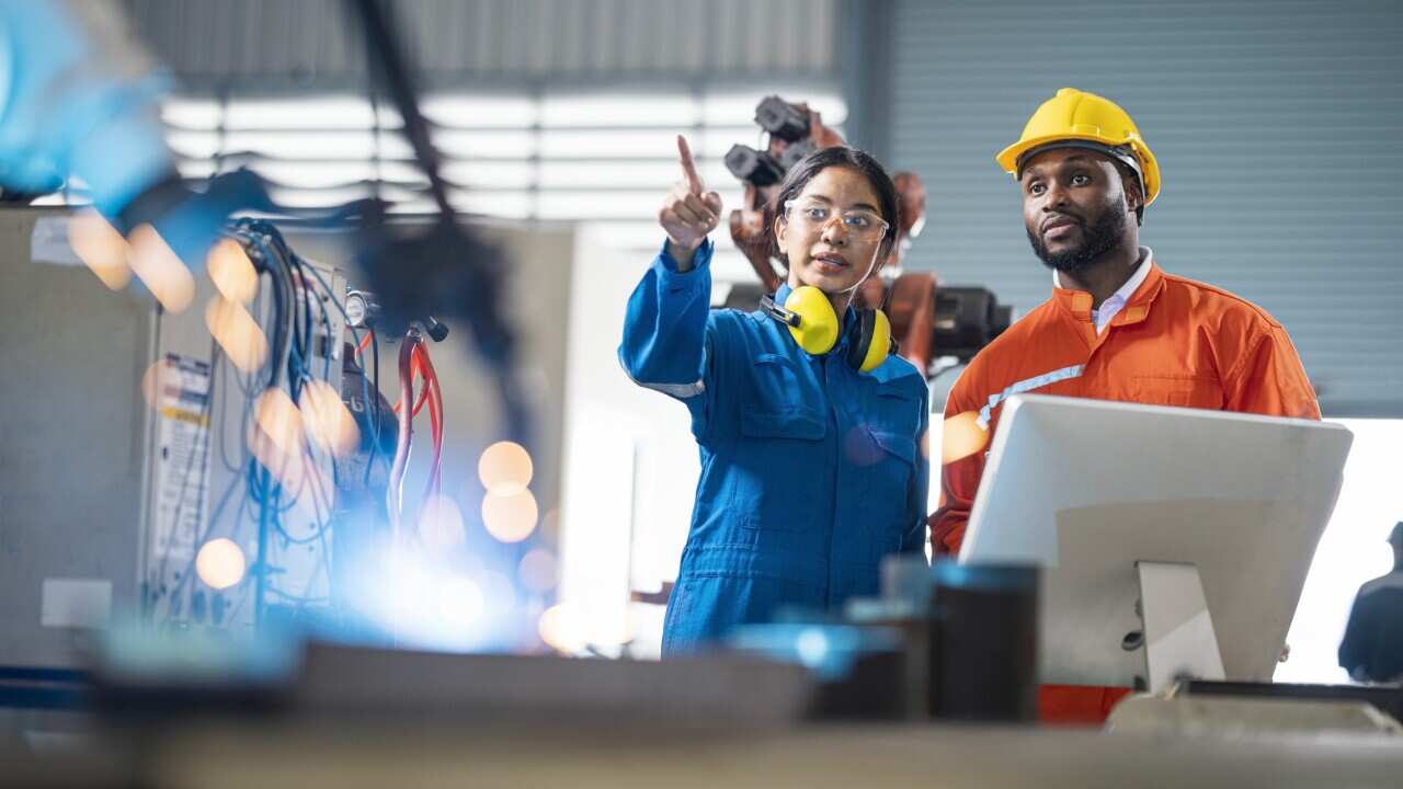 Female engineer presentation robotic welding process to her team in testing area of research and development. Production process improvement concepts.